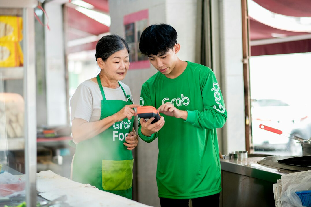 Two Southeast Asian adults reviewing a course on a tablet together
